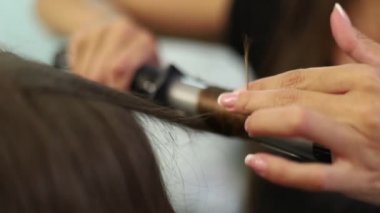 Yakın çekim shot saçlarını Kuaför Salonu doğruldu sahip bir kadın. Saç maşası ağır çekimde vurdu. HD