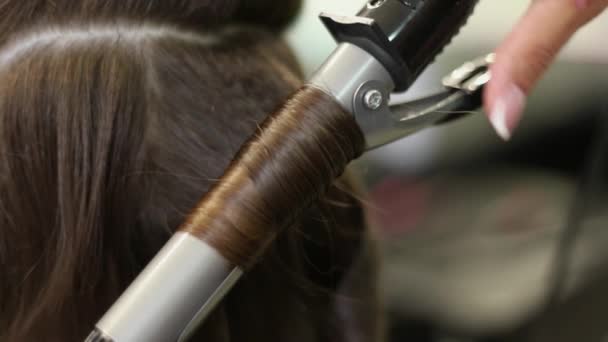 Primer plano de una mujer con el pelo alisado en la peluquería. Curling iron Disparo en cámara lenta. hd — Vídeos de Stock