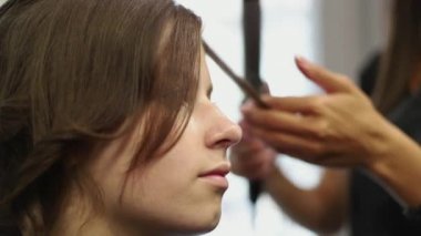 Yakın çekim shot saçlarını Kuaför Salonu doğruldu sahip bir kadın. Saç maşası ağır çekimde vurdu. HD