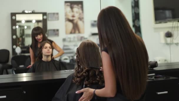 Молодая женщина в парикмахерской подстригается у парикмахера — стоковое видео
