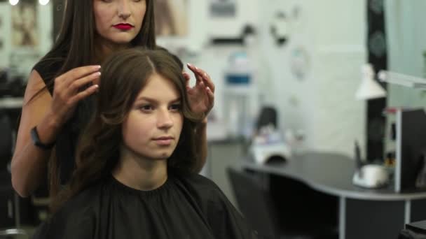 Nahaufnahme einer Frau, die sich im Friseursalon die Haare glätten lässt. Lockenstab-Schuss in Zeitlupe. hd — Stockvideo
