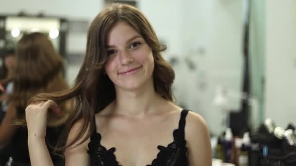 Bellissimo modello in salone di parrucchiere. Bruna ragazza con acconciatura — Video Stock