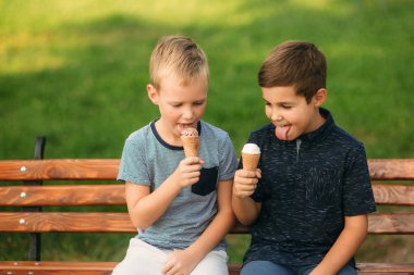 Çocuk bankta oturan ve dondurma yeme