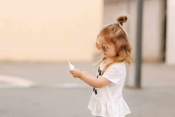 Little girl in sunglasses posing to photographer — Stock Photo, Image