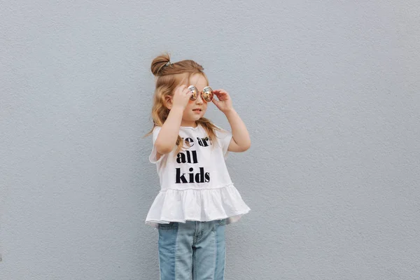Klein meisje in zonnebril poseren voor de fotograaf — Stockfoto