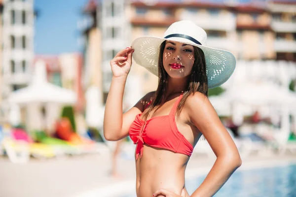 Una dama sexy en un sombrero de playa grande salir de la piscina —  Fotos de Stock