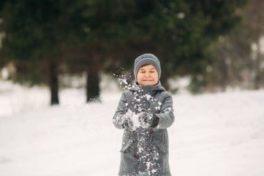 Küçük bir çocuk kış hava Parkta yürüyüşleri, oyun snowballs ve sevindiler. Noel ruh için bekliyor