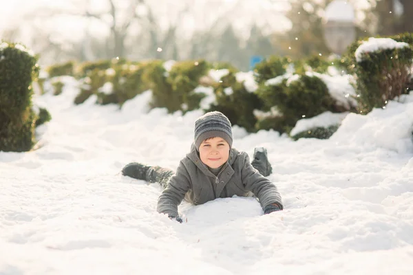 Ein Junge in Winterkleidung springt in den Schnee. frohe Feiertage — Stockfoto