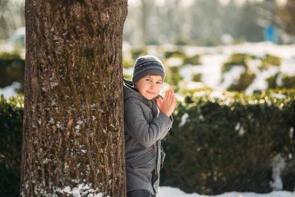 Kleiner hübscher Junge spielt im Park mit Schnee. Weihnachtsstimmung — Stockfoto