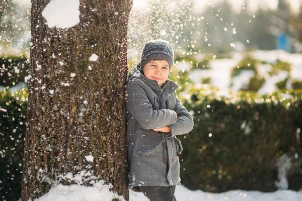 Um menino bonito brinca com neve no parque. Humor de Natal — Fotografia de Stock