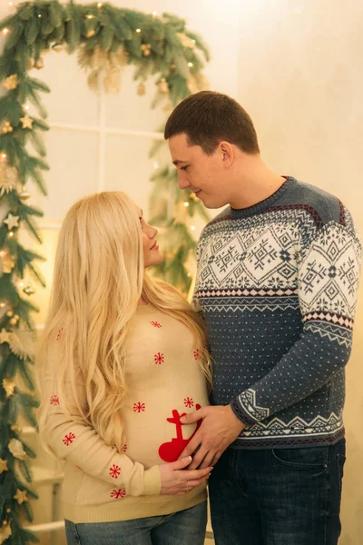 Glückliches Paar in Urlaubsstimmung. Yong fieberhaft in schönen Strickpullovern in Vorfreude auf die Weihnachtsfeiertage — Stockfoto