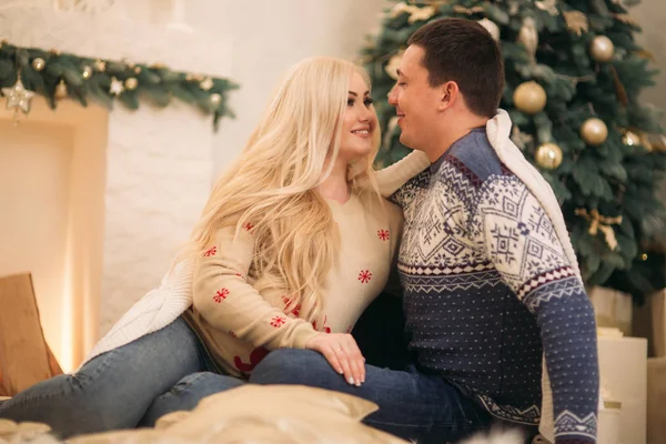 A família feliz senta-se junto à lareira da casa. Humor de Natal — Fotografia de Stock