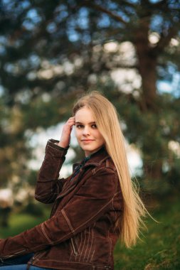 Attrective genç kız tarafından setin oturur. Sarı saçlı ve kahverengi ceket. Bahar