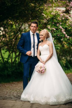 Yakışıklı damat onların düğün günü gelin sarıl. Çiçekli ağaç arka plan