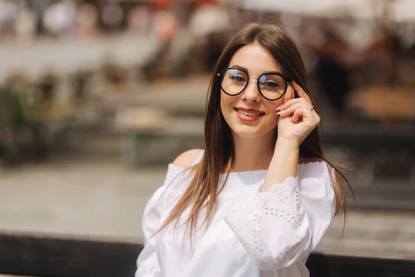 Mooi meisje zit op benth in centrum van de stad — Stockfoto