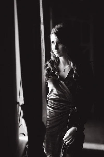 Fekete-fehér fénykép, elegáns modell az ablak mellett — Stock Fotó
