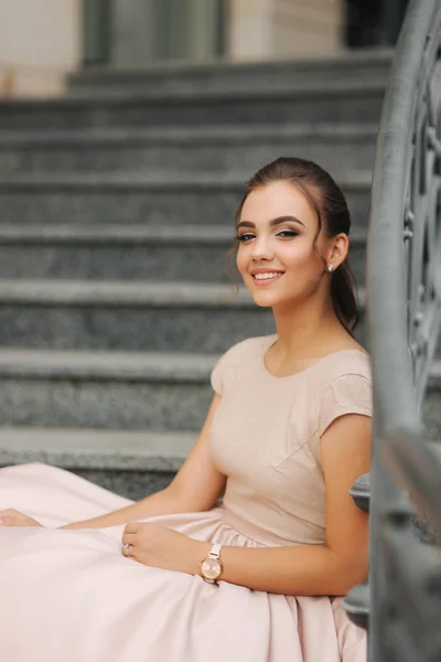 La modelo de moda se sienta en las escaleras junto al hotel. Hermosa dama con peinado moderno — Foto de Stock