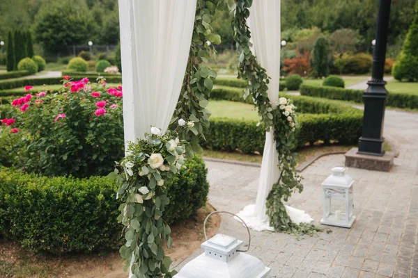 Weddind decoration on open air. Floral decor of a beautiful white arch. Beautiful beckground view of trees — Stock Photo, Image