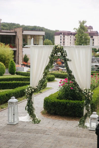 Weddind decoration on open air. Floral decor of a beautiful white arch. Beautiful beckground view of trees — Stock Photo, Image