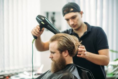 Genç Kuaför berber dükkanı çekici sakallı adam saçını yapmasını eller