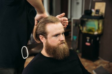 Genç Kuaför berber dükkanı çekici sakallı adam saçını yapmasını eller