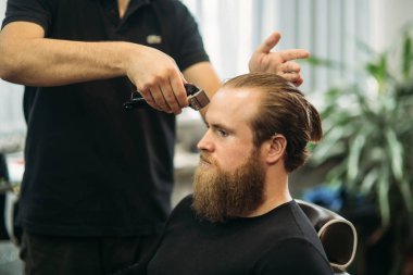 Sakallı adam bir saç kesimi saç kesme makineleri ile sahip