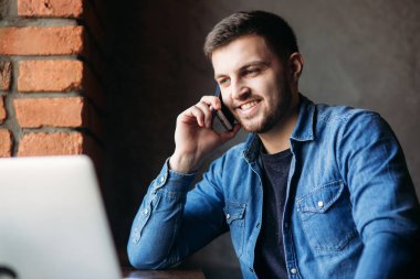 O bir dizüstü bilgisayar kullanırken arama kafede alarak genç işadamı