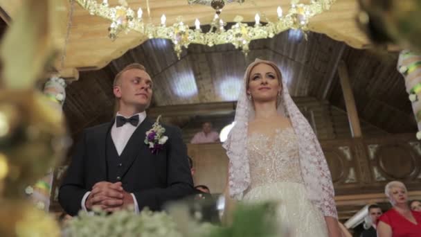 Bräutigam und Braut am Hochzeitstag in der Kirche. Gerade verheiratete Paare. Video — Stockvideo