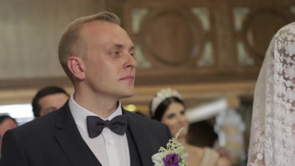 Brudgummen och bruden på sin bröllopsdag i kyrkan. Bara gift par. Video — Stockvideo