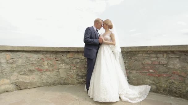 Άνδρας και γυναίκα στα ρούχα του γάμου σταθεί στο κάστρο από την προβολή της πόλης — Αρχείο Βίντεο