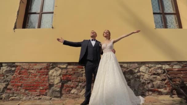 Jonggehuwden lopen in het kasteel op hun trouwdag. De bruid en bruidegom genieten op de huwelijksdag — Stockvideo
