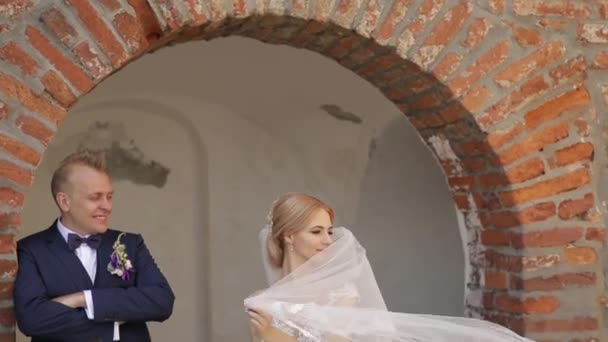 Gli sposi stanno camminando nel castello il giorno del loro matrimonio. La sposa e lo sposo Godersi il giorno delle nozze — Video Stock