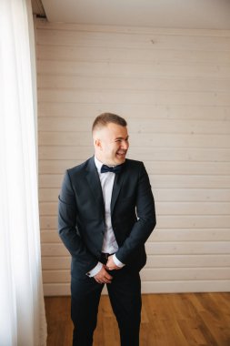 Genç damat evinde giyinmiş. Düğün elbise gülümseme yakışıklı adam