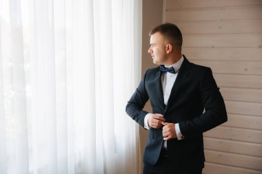 Genç damat evinde giyinmiş. Düğün elbise gülümseme yakışıklı adam