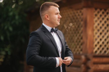 Yakışıklı damat sabah. Düğün günü. Yeşil ağaç arka plan. Yaz saati