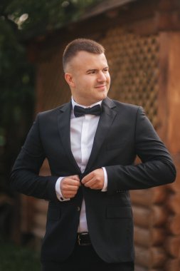 Yakışıklı damat sabah. Düğün günü. Yeşil ağaç arka plan. Yaz saati