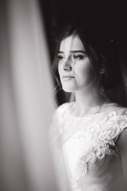 Güzel Gelin stand pencerenin yanında. Sabah sunlights ile. Siyah ve beyaz fotoğraf