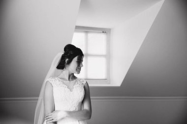 Güzel Gelin stand pencerenin yanında. Sabah sunlights ile. Siyah ve beyaz fotoğraf