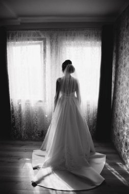 Sevimli gelin stand penceresinin önünde. Odasına pencereden kız beklemede.