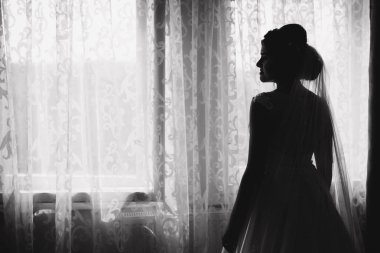 Sevimli gelin stand penceresinin önünde. Kız odasına pencereden beklemede. Siyah ve beyaz. Siluet