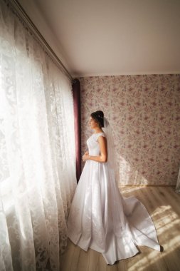 Sevimli gelin stand penceresinin önünde. Odasına pencereden kız beklemede