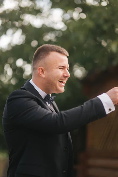 Morgen des hübschen Bräutigams draußen. Hochzeitstag. Hintergrund des grünen Baumes. Sommerzeit — Stockfoto