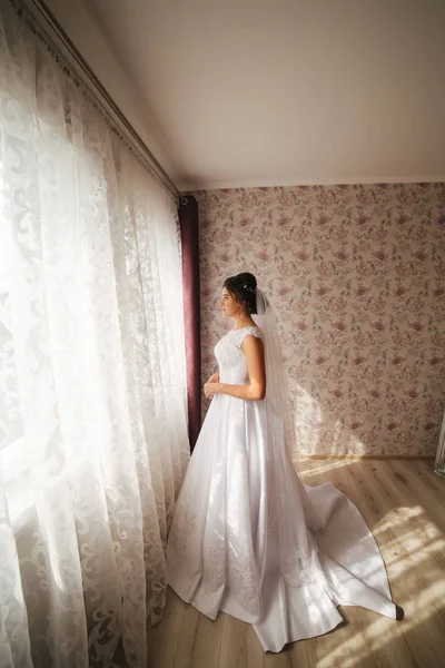 Okouzlující nevěsta postav se před okna. Stojan dívka u okna v pokoji — Stock fotografie