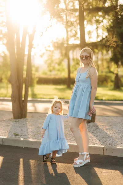 Mom and her daughter walking and holding hands — Stock Photo, Image