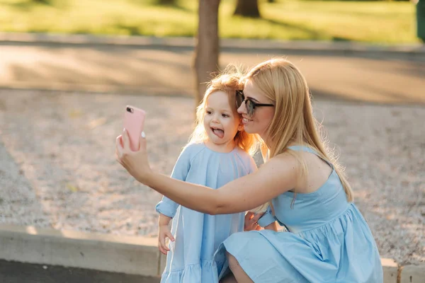 Mutter und kleine Tochter machen Selfie im Park — Stockfoto