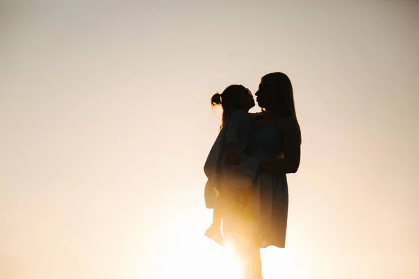 Silhueta de mãe e filhinha. Pôr do sol — Fotografia de Stock