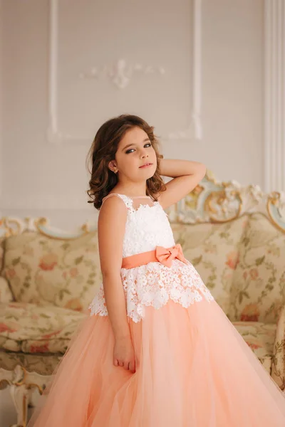 Счастливая маленькая принцесса в красивом платье ходить хотя большая студия — стоковое фото