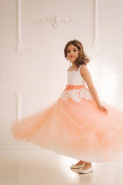 Happy little princess in beautiful dress walk though the big studio — Stock Photo, Image