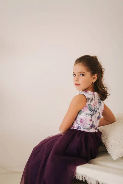 Menina bonita em um vestido roxo e blusa de flor posando para um fotógrafo — Fotografia de Stock