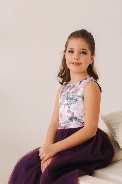 Menina bonita em um vestido roxo e blusa de flor posando para um fotógrafo — Fotografia de Stock